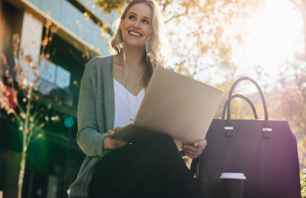 istock Woman sitting outdoors with a laptop 1218557698
