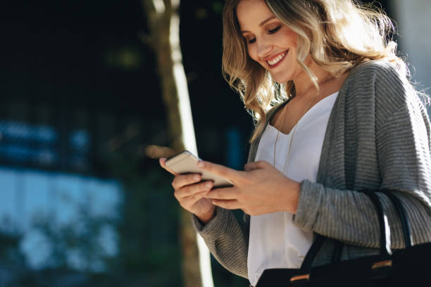 istock Woman walking in the city using her cell phone 1218557745