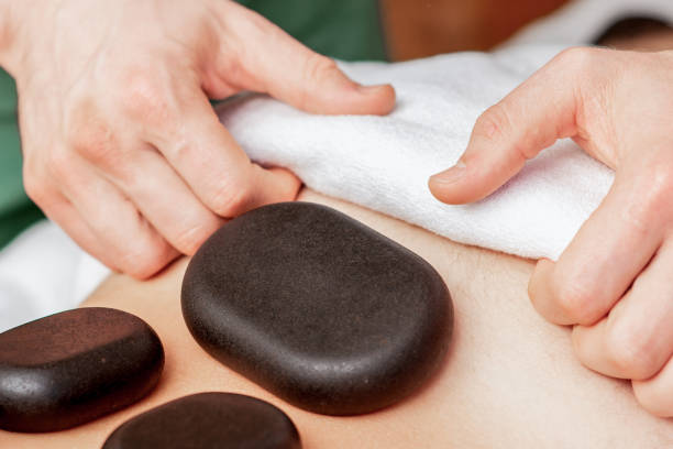 istock Stone massage on back of man. 1218564529