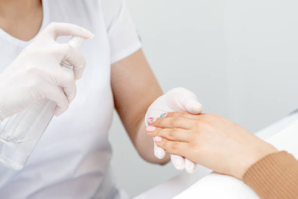 istock Manicurist is appies spray on client hand. 1218565413