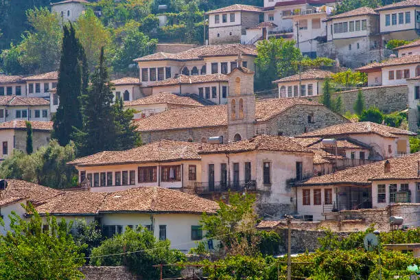 Albania - Berat - Historical white houses under red tile with church and bell tower in UNESCO world heritage site
