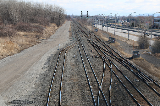 Railway tracks at the end of a railway yard converge on the line leaving town.