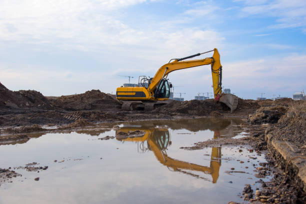 istock Excavator at lake in the quarry on sunset background. Backhoe during earthmoving work at open-pit mining. Earth-moving heavy equipment. Small roughness sharpness, possible granularity 1218569646