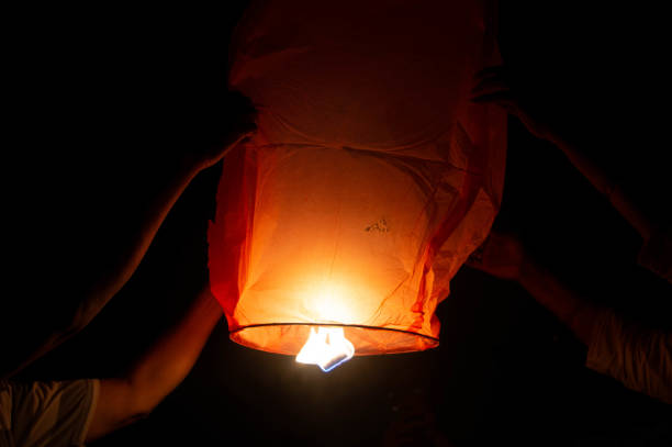 istock Person holding a red sky lantern with the flames showing clearly 1218569867