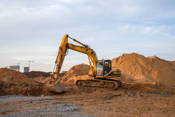 istock Excavator working at construction site. Backhoe digs ground for the foundation and for paving out sewer line. Construction machinery for excavating, loading, lifting and hauling of cargo on job sites 1218570321