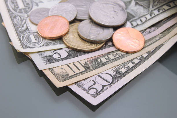 istock American dollars, various dollar bills, and coins, close-up on dark background. 1218571084