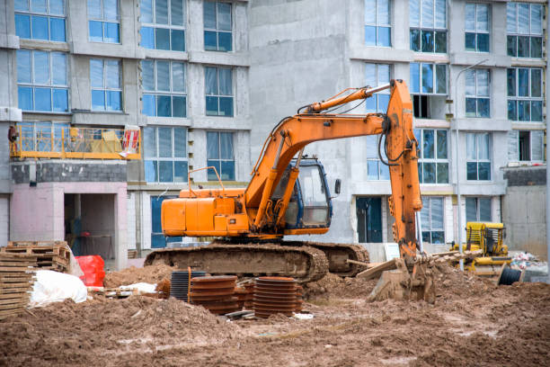 istock Excavator working at construction site. Backhoe digs ground for the foundation and for paving out sewer line. Construction machinery for excavating, loading, lifting and hauling of cargo on job sites 1218571468