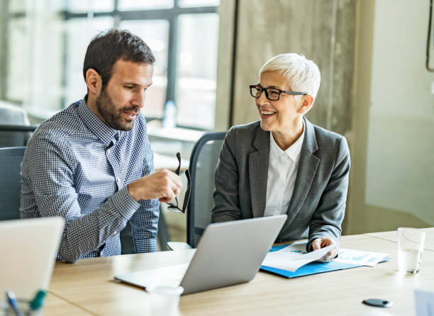 istock Happy business colleagues talking while working in the office. 1218572207