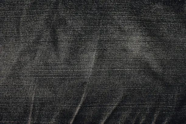 Photo of Texture of black denim jeans for background. denim jeans with old torn of fashion jeans design