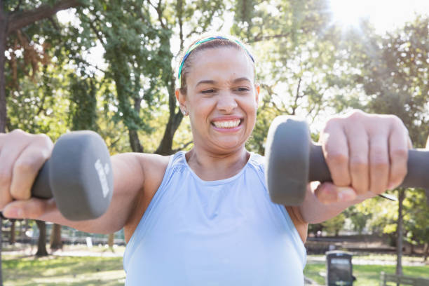 istock woman exercising outside in the park 1218573408