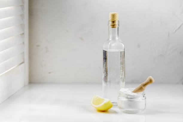 Vinegar, baking soda and lemon on white background