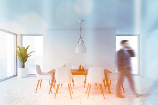 istock Man walking in white stylish dining room 1218575836