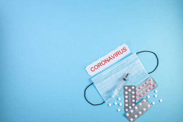 istock Protective medical mask and pills on blue background. 1218577106