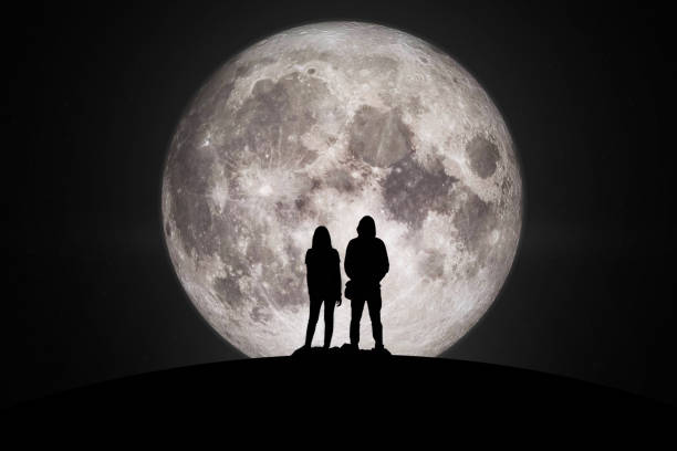 silhouette of man and women  looking at the moon with hope fulfillment in love. elements of this image furnished by nasa. - valentine imagens e fotografias de stock