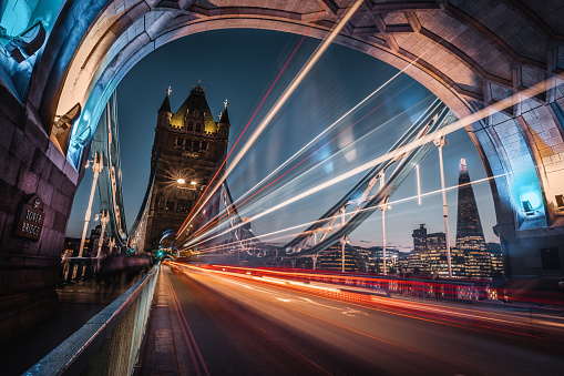 Long exposure low to the ground with blue sky, archway and tower of Tower Bridge