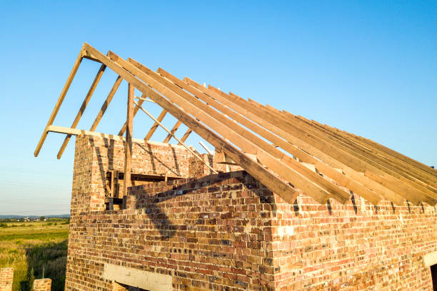 istock Unfinished brick house with wooden roof structure under construction. 1218582802