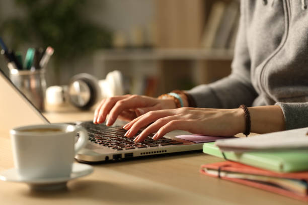 istock Student hands typing on laptop in the night at home 1218585953
