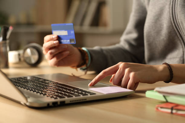 mani degli studenti che pagano con carta di credito su laptop di notte - serving people teenage girls female foto e immagini stock