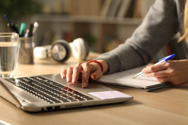 Student hands comparing notes on laptop at night Close up of student girl hands comparing notes on laptop sitting on a desk at home at night exam student university writing stock pictures, royalty-free photos & images