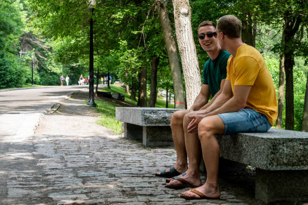 istock Homosexual couple talking on a park bench in summer. 1218586461