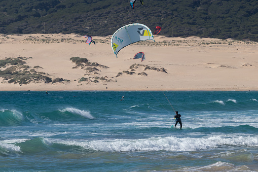 Tarifa, Spain. 3rd February, 2020.  Kitesurfer in the Atlantic ocean near the windy Bolonia beach with african mountains in the background