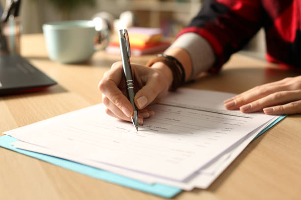 istock Student girl hand filling out form at night 1218588183