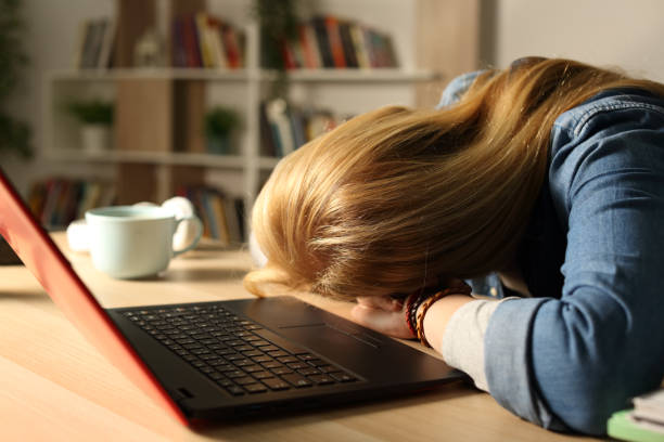 istock Overworked student with laptop sleeping at night over desk 1218588620