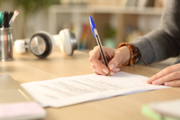 istock Student hands signing contract at home 1218589394