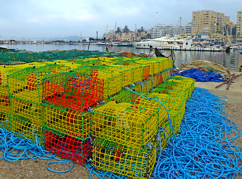 Colorful traps used for fishing lobster and crab, stacked up in the harbor in Estepona Spain.