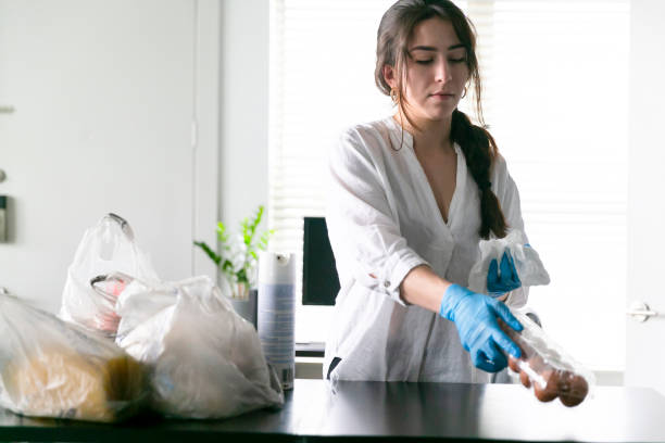 istock Woman disinfects groceries 1218592248