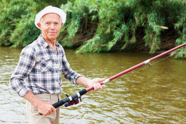 istock Mature man angling at riverside 1218592432