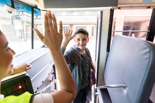 istock Boy entering bus after school gives driver high five 1218592579