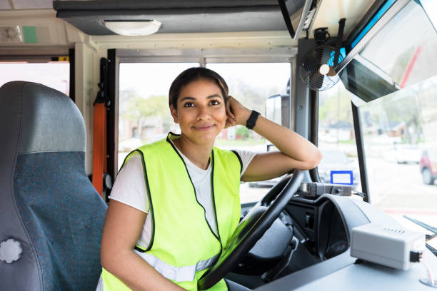 istock Leaning on steering wheel, cheerful bus driver smiles for camera 1218592603