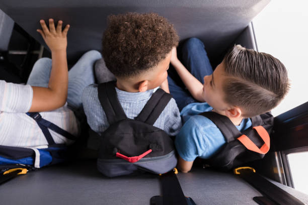 istock High angle view three school boys sitting on bus 1218592650
