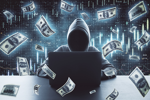 Hacker using laptop and falling dollar bills. Hacking and financial success concept