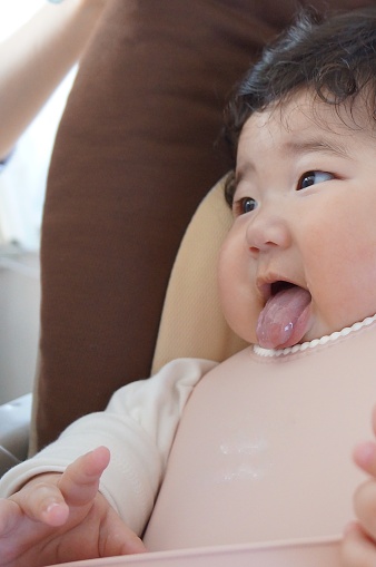 Bebé de 5 meses de edad sentado en una silla de bebé después de comer comida para bebés. photo