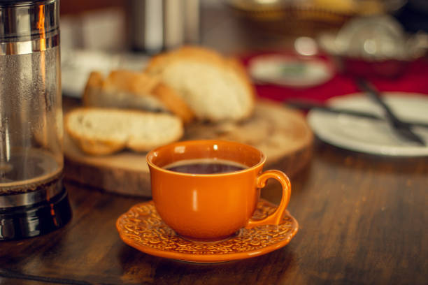 Cup of tea on wooden table with warm scarf, autumn minimal still life, atmosphere mood. Sepia toned