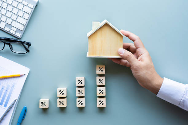 A man holding a miniature house after arranging cubes with percentage icon