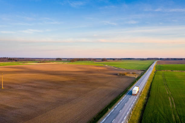 istock Aerial view of a highway passing through spring agricultural fields at sunset 1218604301