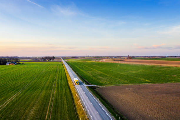 istock Aerial view of a highway passing through spring agricultural fields at sunset 1218604303
