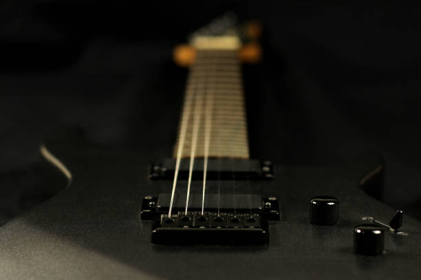 istock Grey electric guitar on a black background, selective focus 1218604599