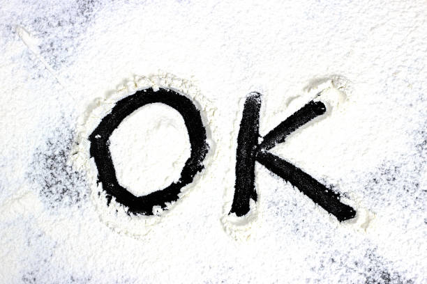 istock OK word is drawn with finger on flour, white powder 1218604645