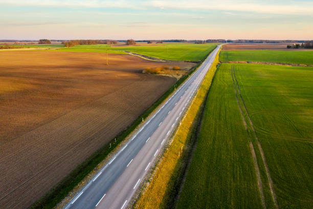 istock Aerial view of a highway passing through spring agricultural fields at sunset 1218604788