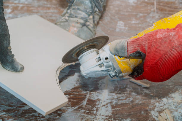 istock Man professional worker cutting tile with circular saw electric 1218609196