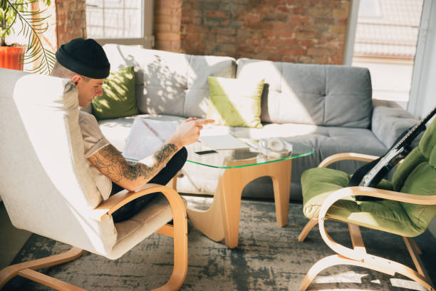 istock Young man studying at home during online courses or free information by hisself 1218609498