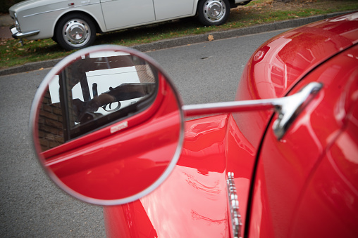 round side mirror of a red retro car