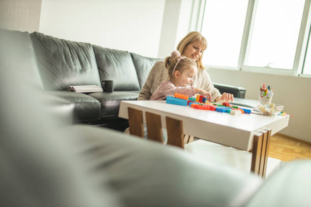 istock Mother and daughter playing with toy bricks 1218609811