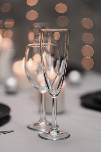 istock A table set in the restaurant. Serving a table. Grey artistic background. Black matte utensils, glass glasses. White candles and decor. Festive yellow lights garland in the background. 1218610973