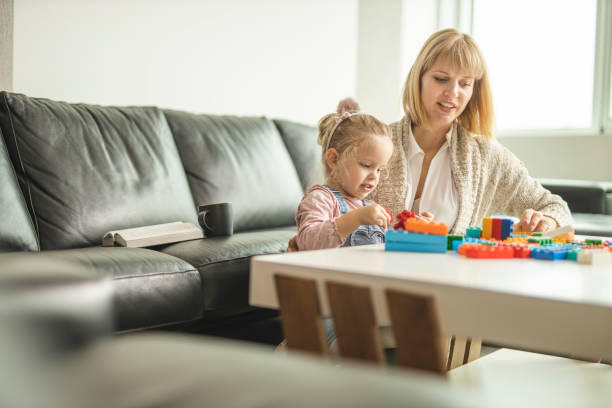 istock Mother and daughter playing with toy bricks 1218612392