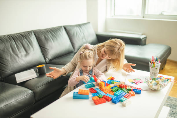 istock Mother and daughter playing with toy bricks 1218612554